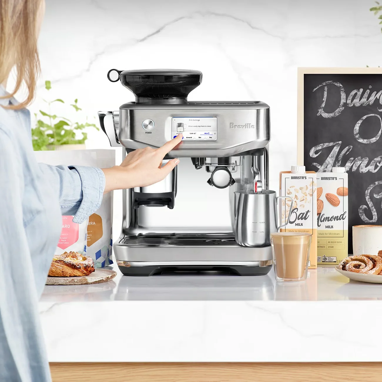 Barista pouring frothed milk into a flavored coffee drink
